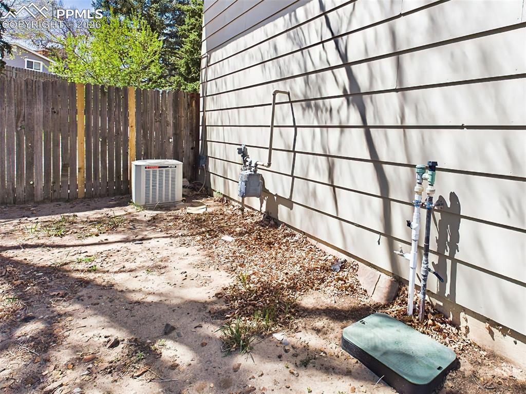 Image 49 of 50: Side Yard/Exterior – Functional side yard featuring Central AC & Sprinkler 