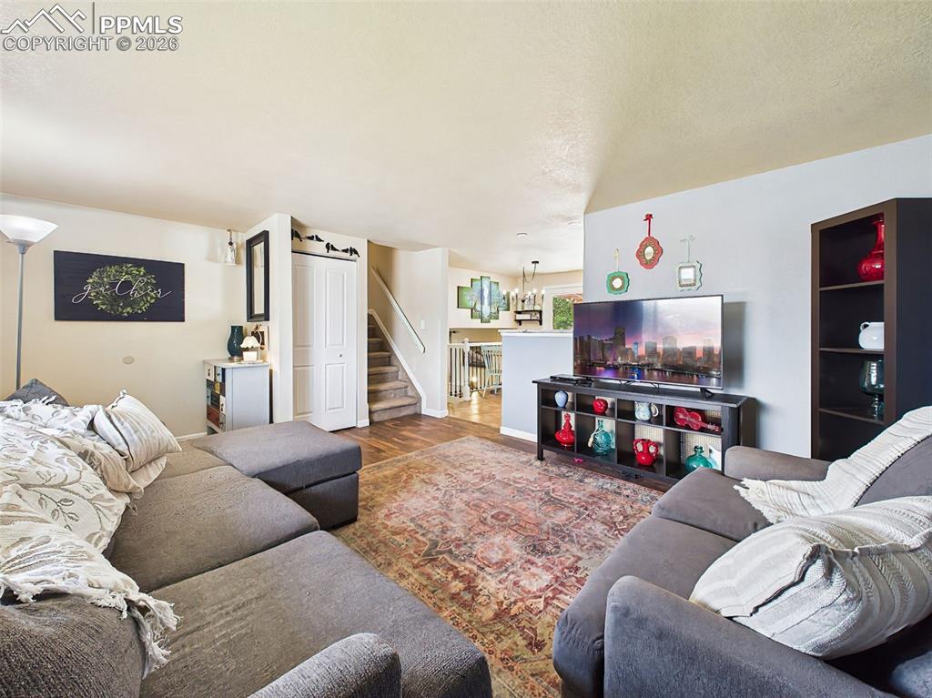 Image 7 of 50: Inviting living area with plush seating, wood-style flooring, and a large a