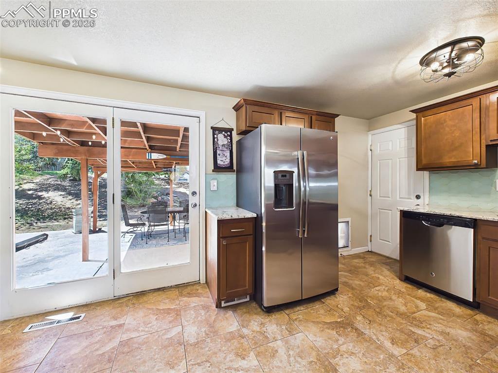 Image 9 of 50: Bright eat-in space with a charming light fixture and sliding door access t