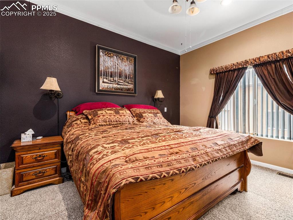 Image 15 of 46: Carpeted bedroom with ornamental molding and baseboards