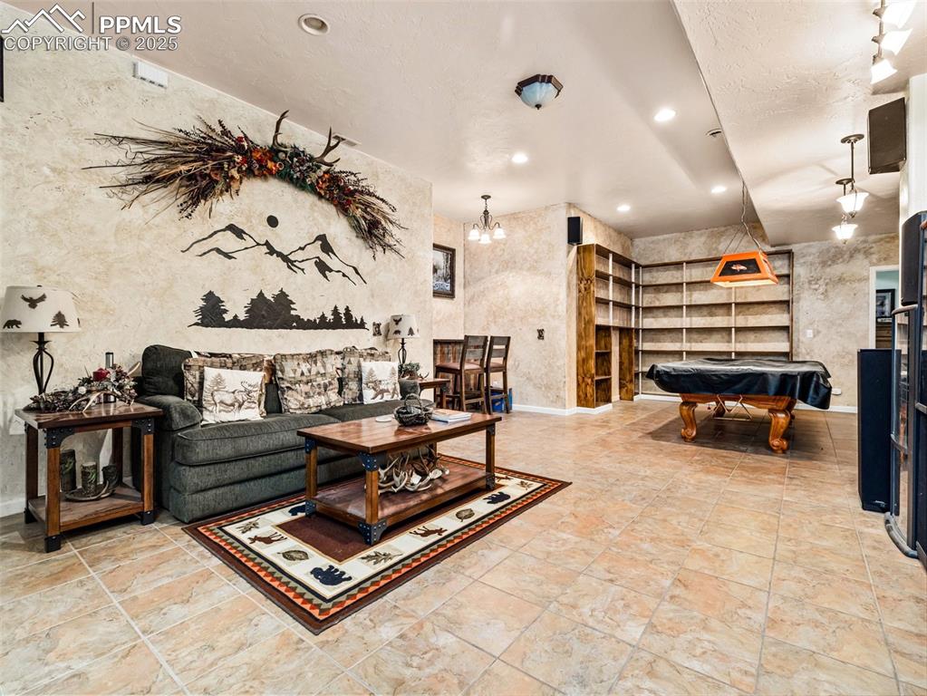 Image 21 of 46: Living room with billiards table and recessed lighting