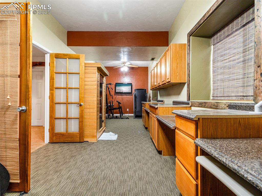 Image 31 of 46: Kitchen featuring light colored carpet, a ceiling fan, brown cabinets, and 