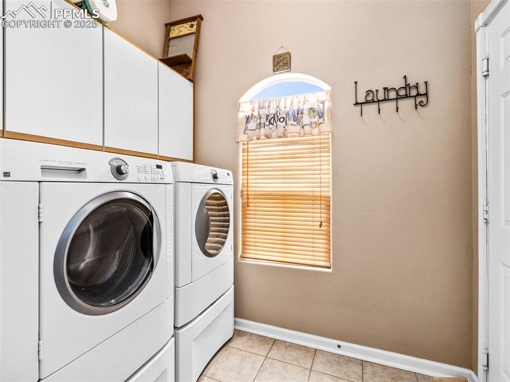 Image 33 of 46: Laundry room with light tile patterned floors, independent washer and dryer