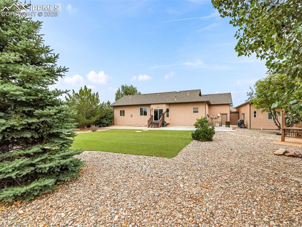 Image 37 of 46: Back of property featuring a patio, a yard, stucco siding, and entry steps