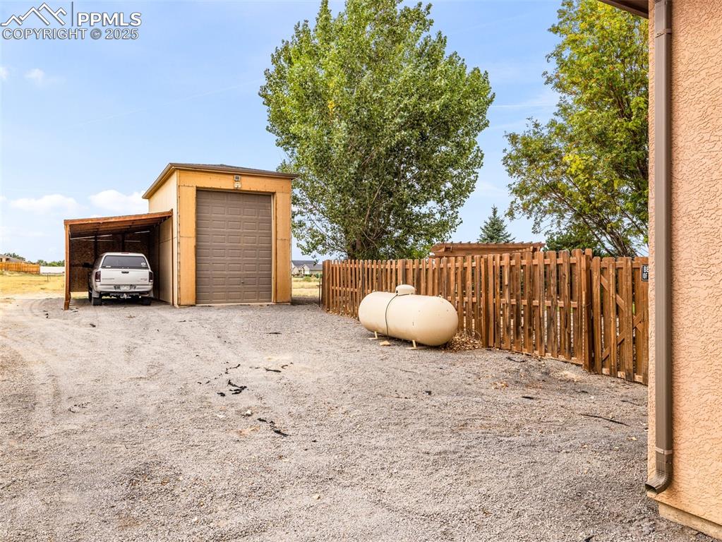 Image 39 of 46: View of yard featuring a carport and driveway