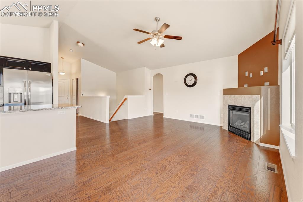 Image 10 of 35: Living room with vaulted ceilings, fireplace and ceiling fan.