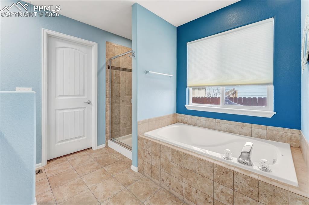 Image 16 of 35: Primary bathroom with soaking tub and separate shower.