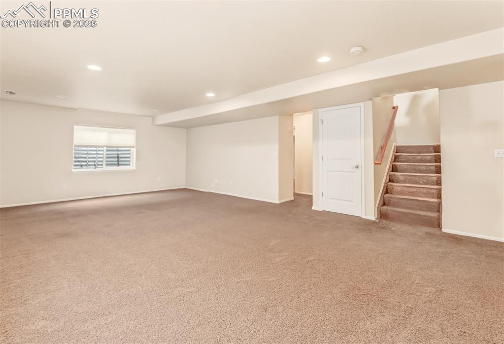 Image 21 of 35: Large entertainment space in the basement looking toward the stairs on hall