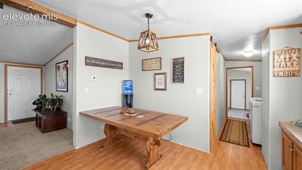 Image 10 of 40: Open-concept dining area featuring wood-finish flooring, a rustic wood tabl