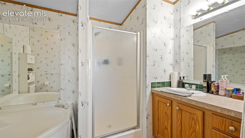 Image 17 of 40: Bathroom featuring a corner soaking tub, a stand-up shower with a frosted g
