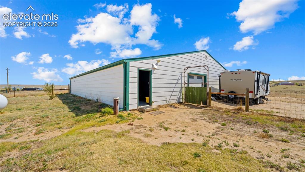 Image 20 of 40: Outbuilding with white siding, green trim, and a metal roof