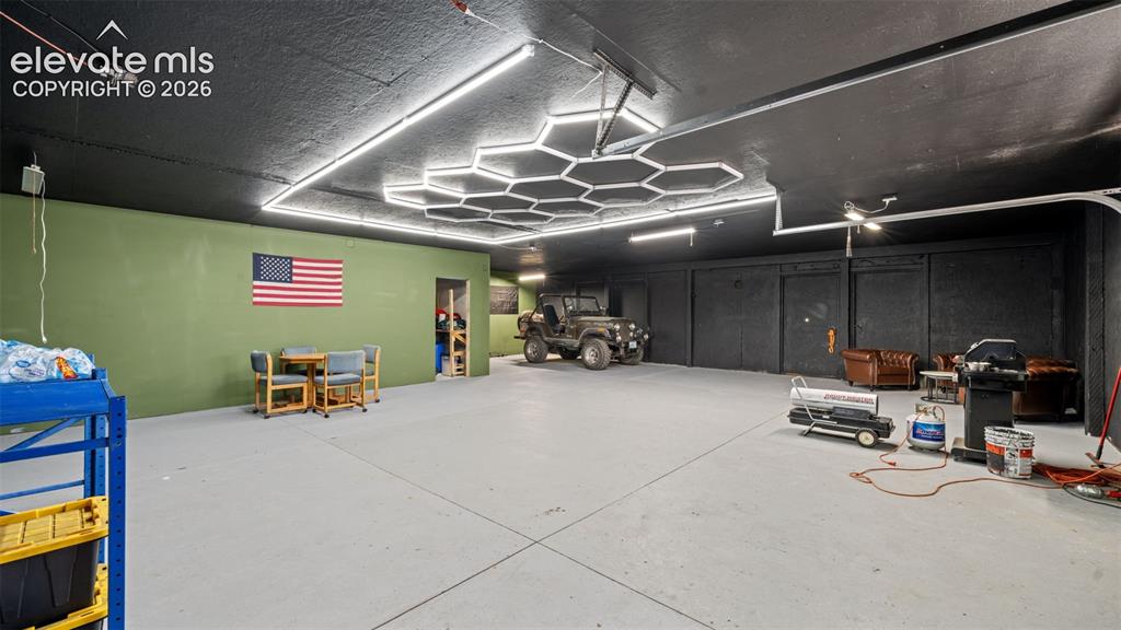 Image 22 of 40: Spacious interior space featuring a concrete floor and a black ceiling