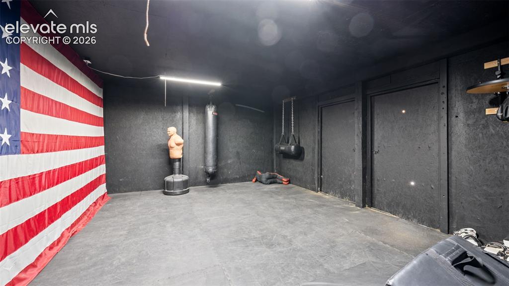 Image 23 of 40: Finished basement area featuring dark-toned walls, recessed lighting, and d