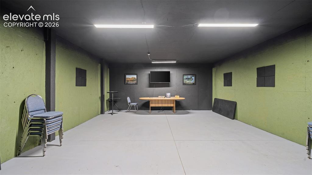 Image 24 of 40: Spacious room featuring lime green wall panels, a dark gray ceiling, light