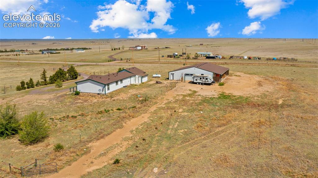 Image 31 of 40: Expansive property featuring a ranch-style residence and a large outbuildin