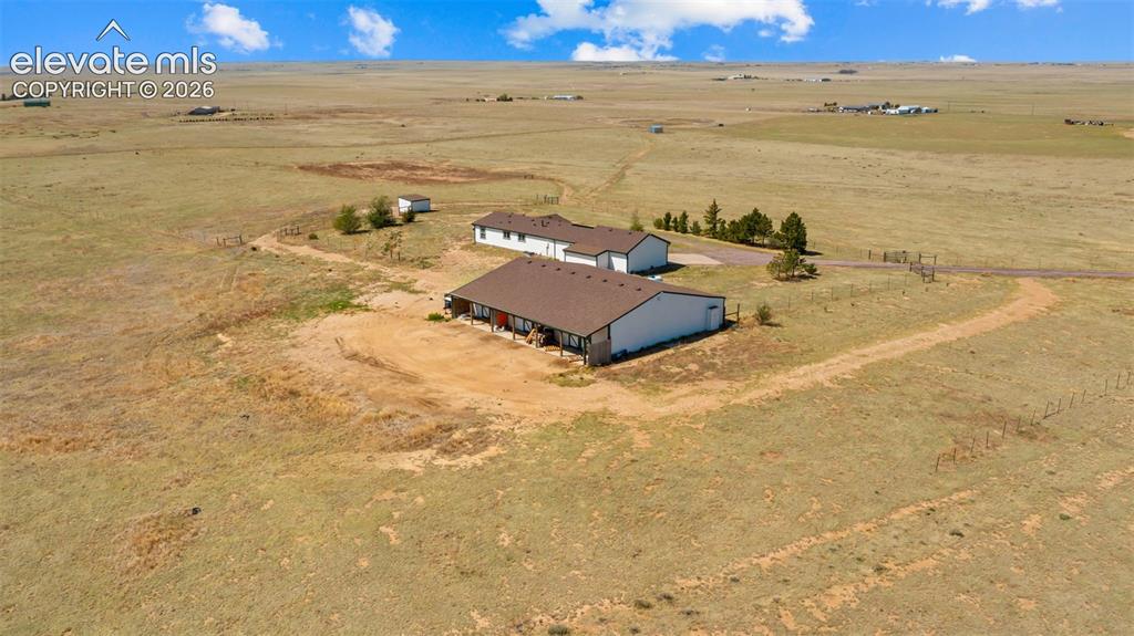 Image 32 of 40: Expansive property featuring a main residence with a covered porch, a separ