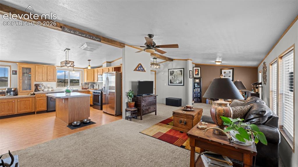 Image 4 of 40: Open-concept interior featuring light wood-finish flooring, a kitchen islan