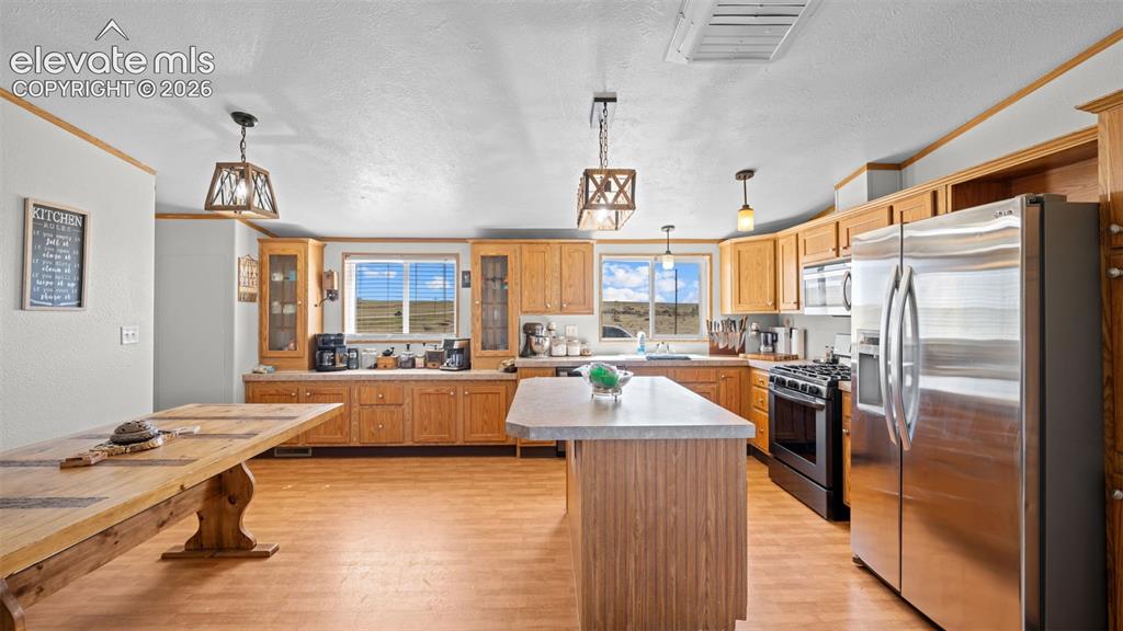Image 9 of 40: Spacious kitchen featuring light wood cabinetry, stainless steel appliances