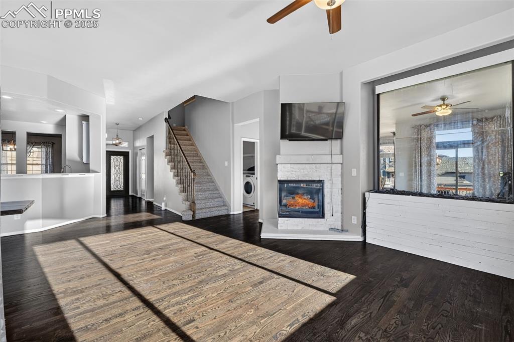 Image 13 of 50: Living area featuring ceiling fan, plenty of natural light, a glass covered