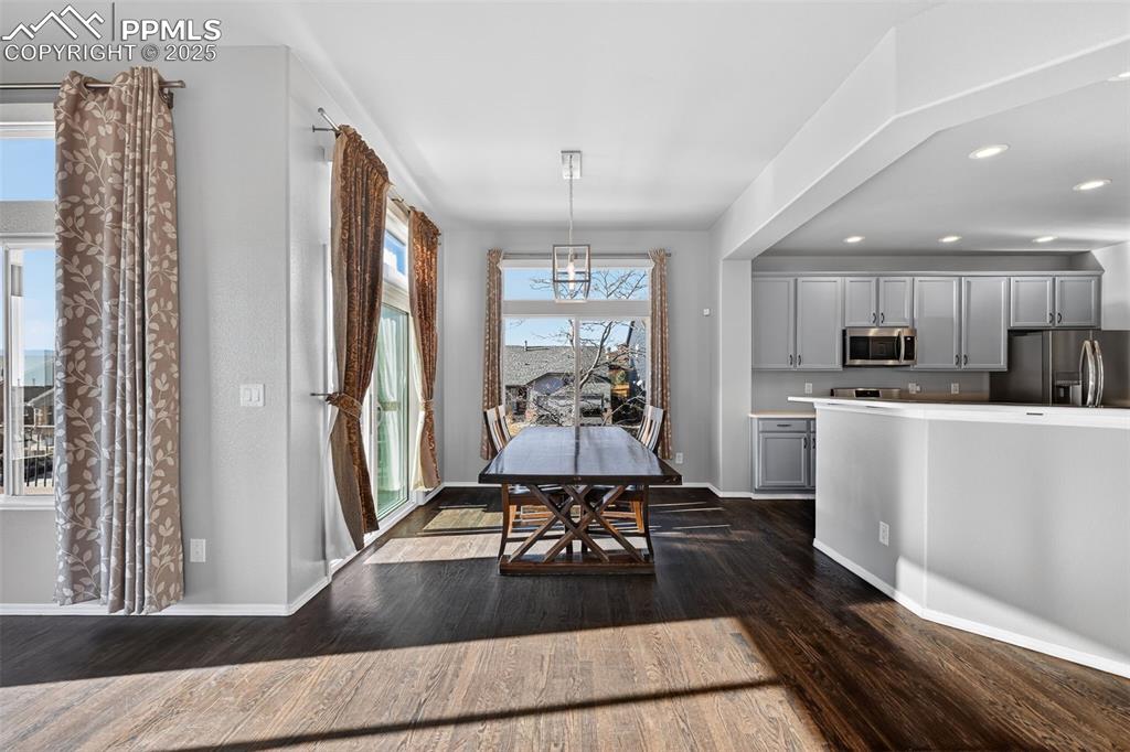 Image 15 of 50: Dining space featuring dark wood-style floors and recessed lighting