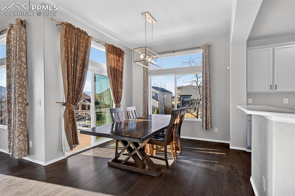 Image 17 of 50: Dining room with a chandelier and dark wood-style floors