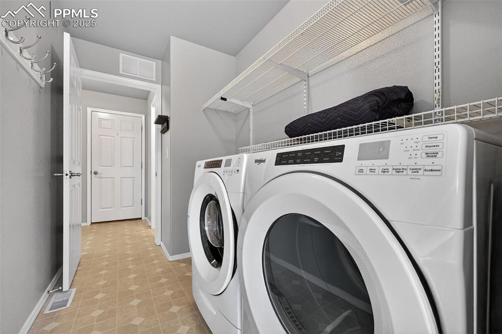Image 26 of 50: Washroom featuring light flooring and washing machine and dryer