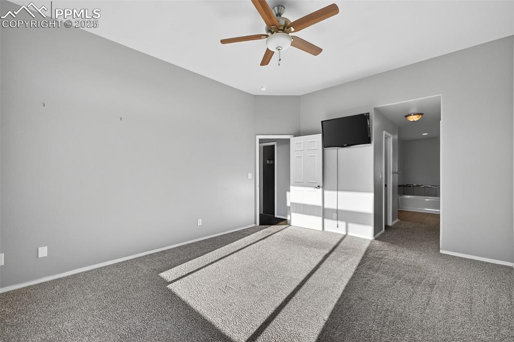 Image 29 of 50: Unfurnished bedroom featuring carpet, a ceiling fan, connected bathroom, an