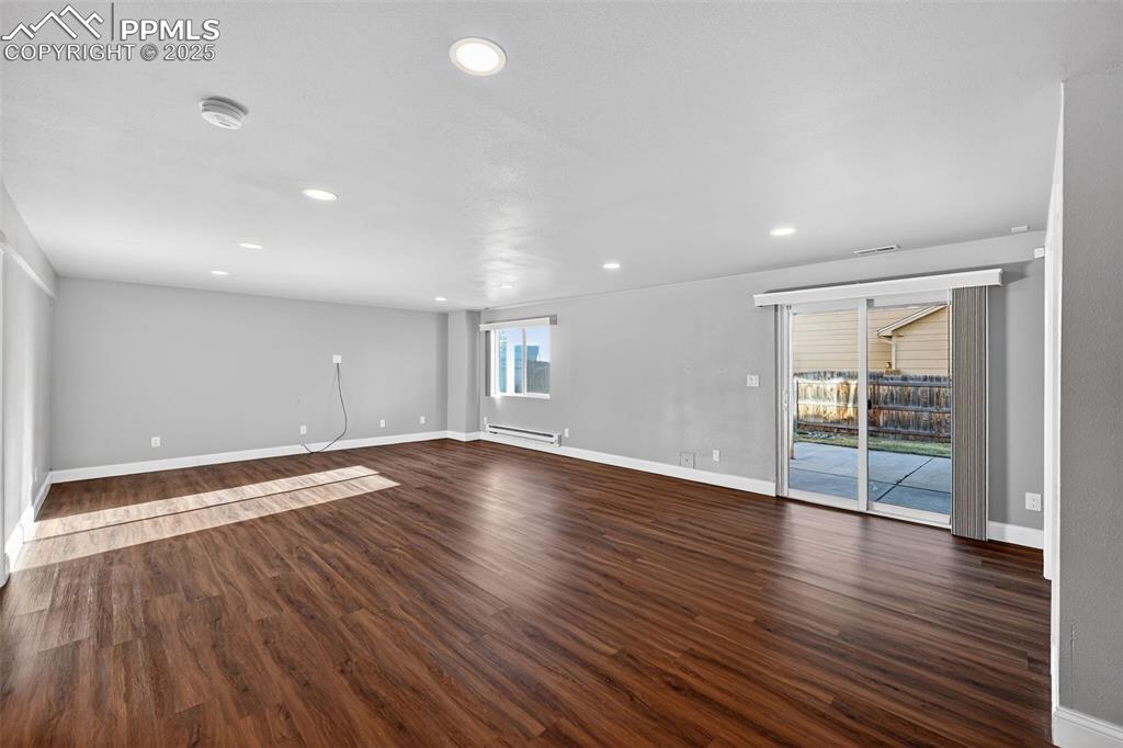 Image 38 of 50: Spare room with dark wood finished floors, recessed lighting, and baseboard
