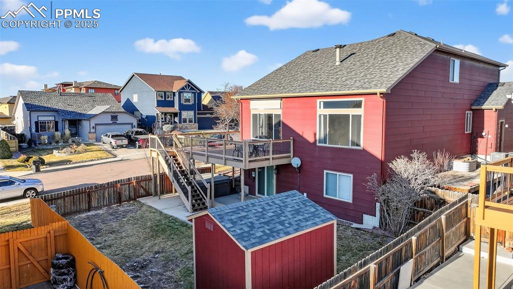 Image 50 of 50: Rear view of property featuring a fenced backyard, a wooden deck, a residen