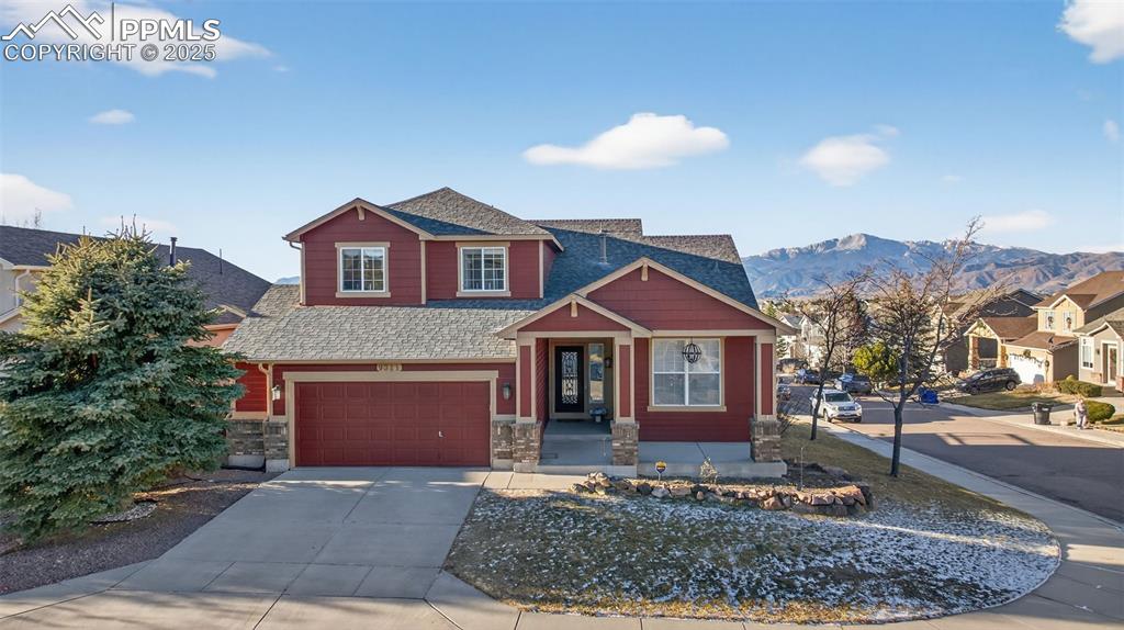 Image 6 of 50: Craftsman inspired home with concrete driveway, a shingled roof, stone sidi