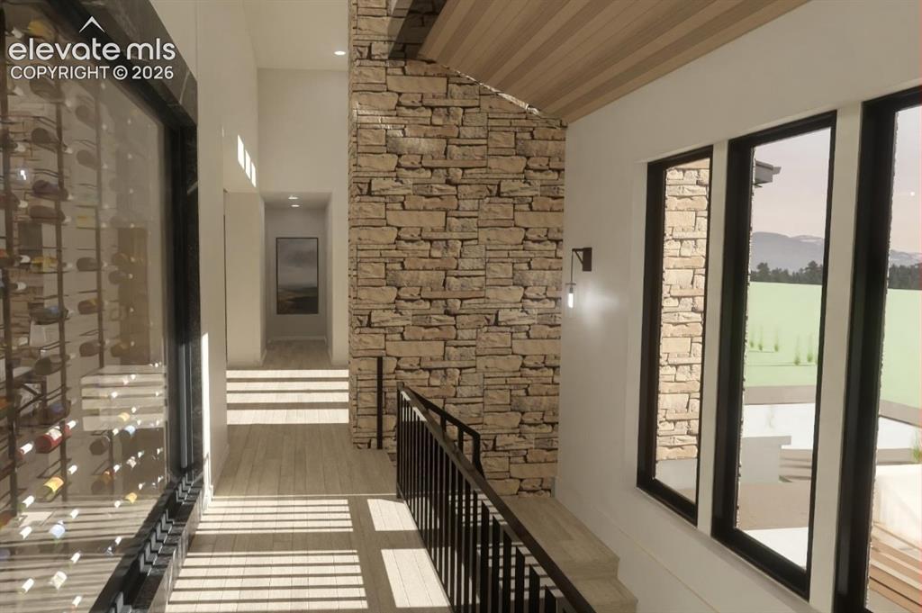 Image 14 of 24: Stone accent wall, wood-finish flooring, black framed windows, black metal 