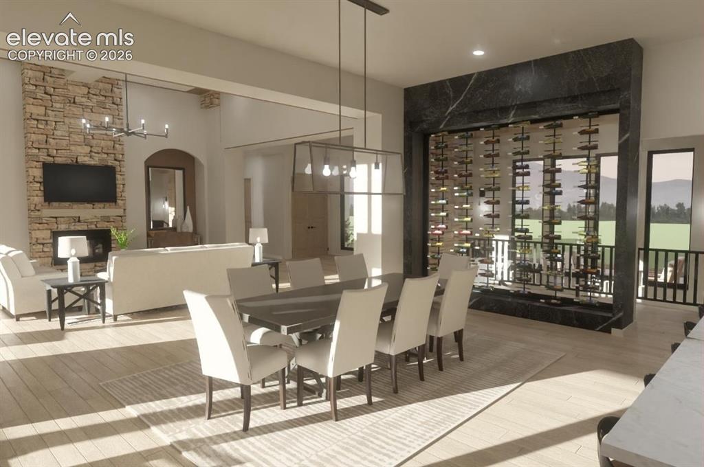 Image 15 of 24: Open-concept living area featuring a stone fireplace, vaulted ceilings, and
