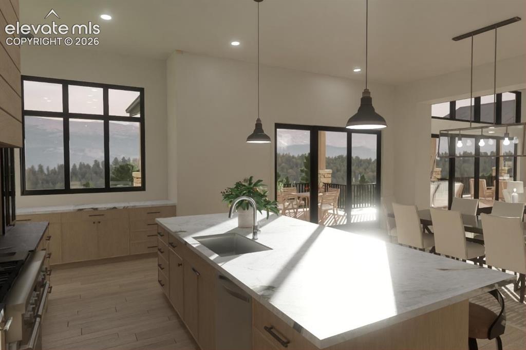 Image 17 of 24: Spacious kitchen featuring a large central island with an undermount sink, 
