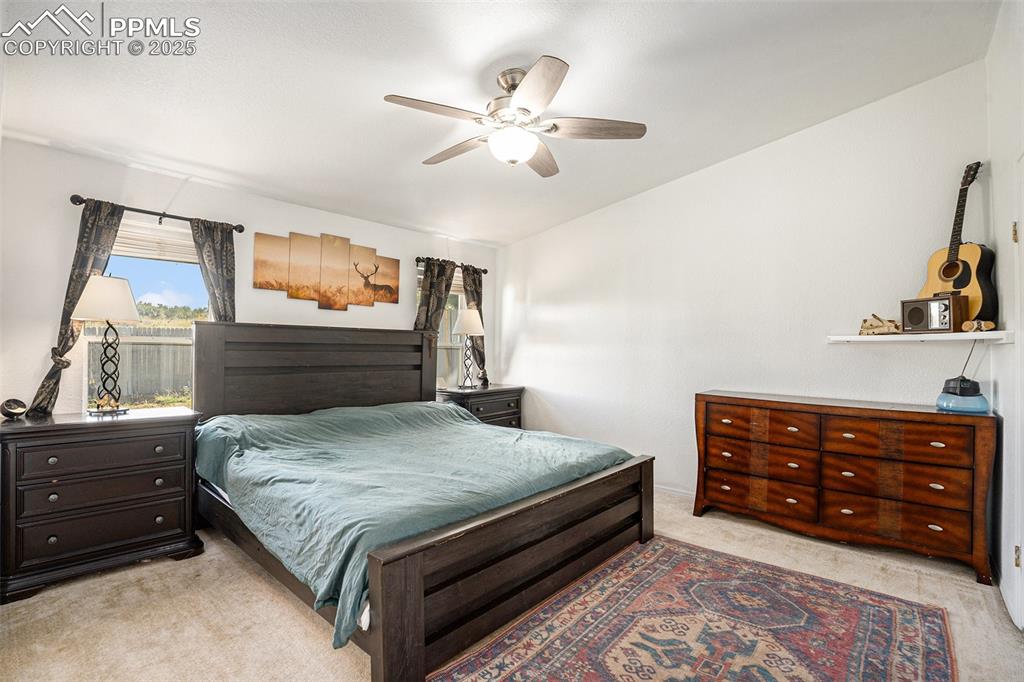 Image 12 of 24: Bedroom featuring light colored carpet and a ceiling fan