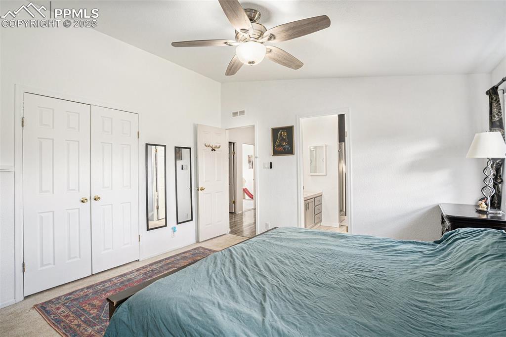 Image 14 of 24: Bedroom with vaulted ceiling, ceiling fan, light colored carpet, a closet,