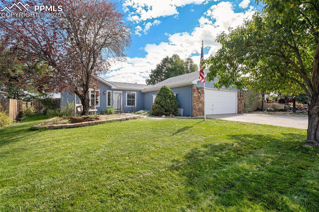 Image 2 of 24: View of front of house with driveway, stone siding, and an attached garage