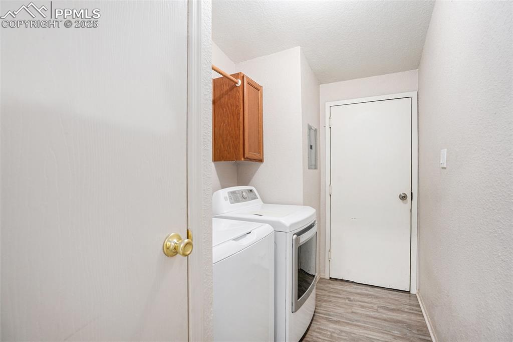 Image 20 of 24: Washroom featuring light wood-type flooring, cabinet space, a textured ceil