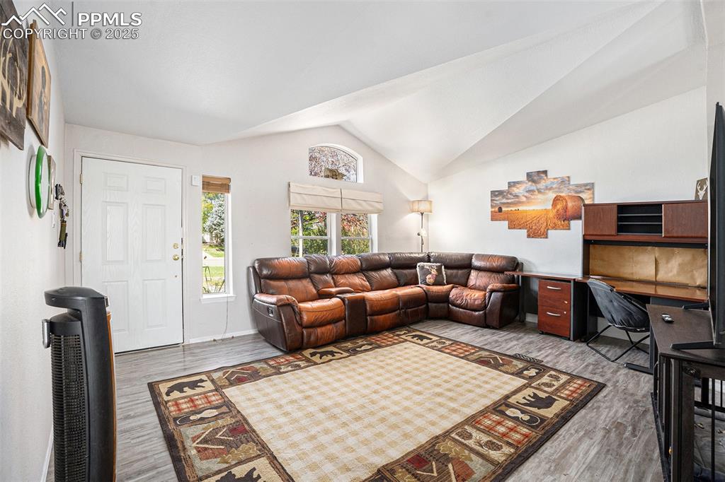 Image 5 of 24: Living room with light wood-style flooring, high vaulted ceiling, and an of