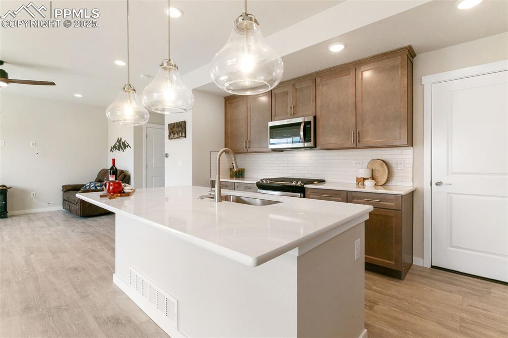Image 10 of 50: Kitchen featuring recessed lighting, decorative backsplash, stainless steel