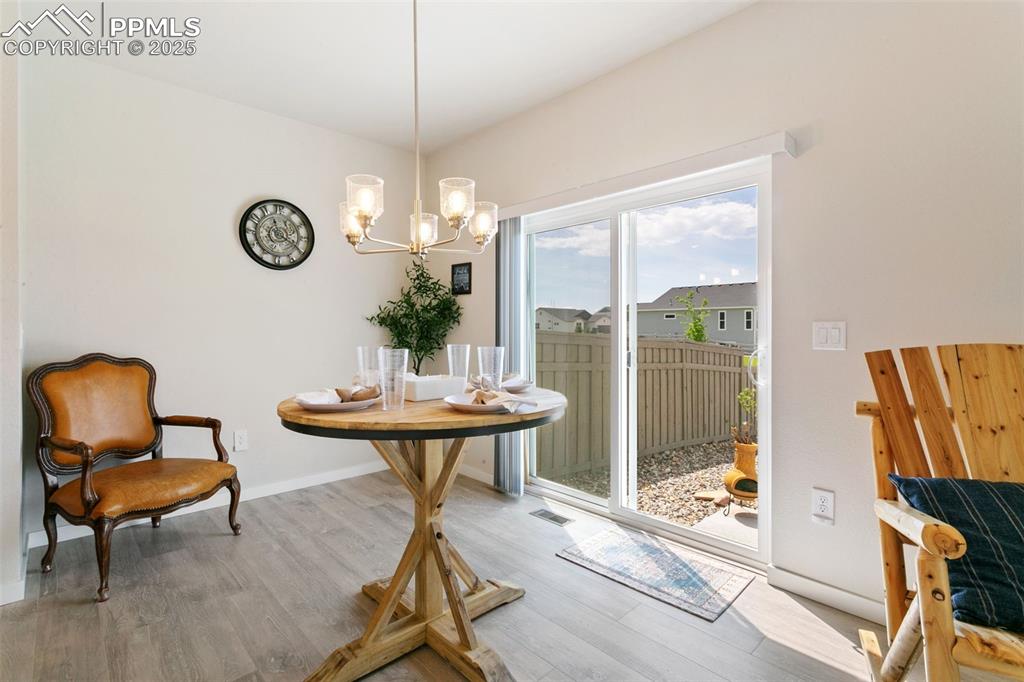 Image 11 of 50: Dining room with a chandelier and wood finished floors