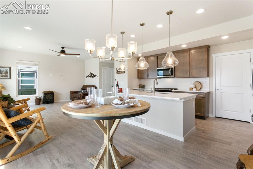 Image 12 of 50: Kitchen featuring recessed lighting, ceiling fan, decorative backsplash, li