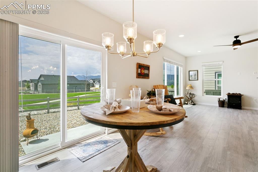 Image 13 of 50: Dining area with wood finished floors, a chandelier, recessed lighting, and