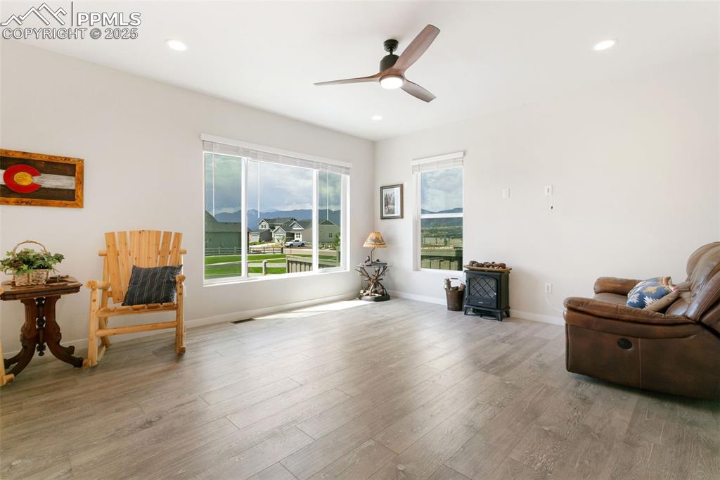 Image 15 of 50: Sitting room with wood finished floors, ceiling fan, and recessed lighting