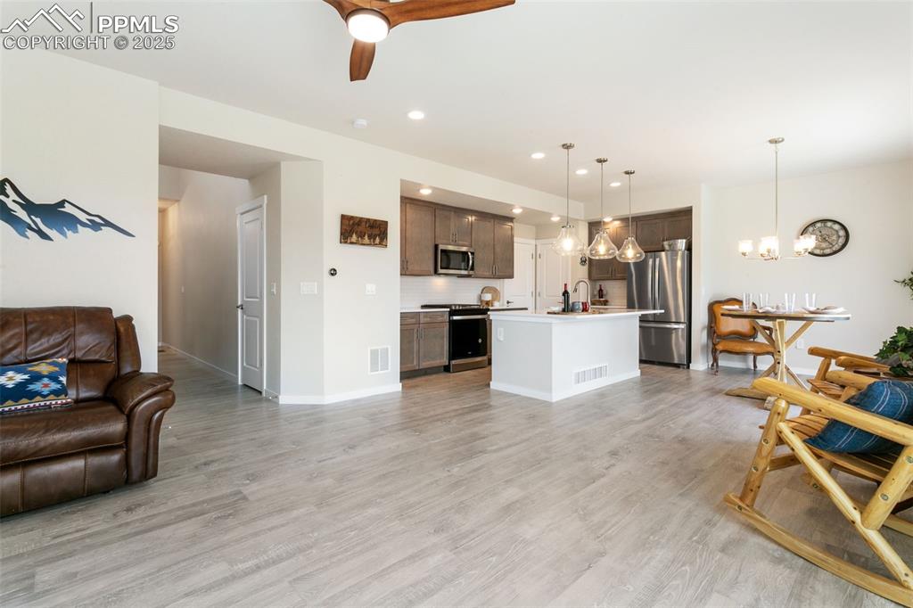 Image 18 of 50: Living room featuring a chandelier, recessed lighting, a ceiling fan, and l
