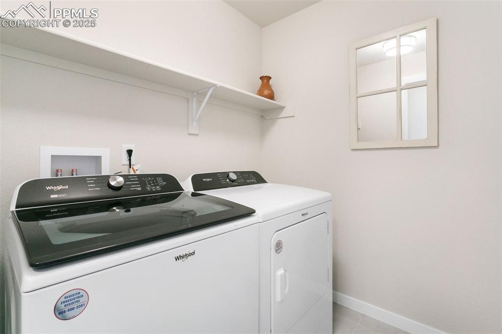 Image 20 of 50: Laundry area featuring washer and clothes dryer and light tile patterned fl