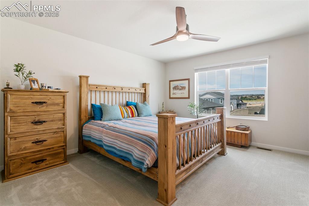 Image 23 of 50: Bedroom featuring light colored carpet and ceiling fan