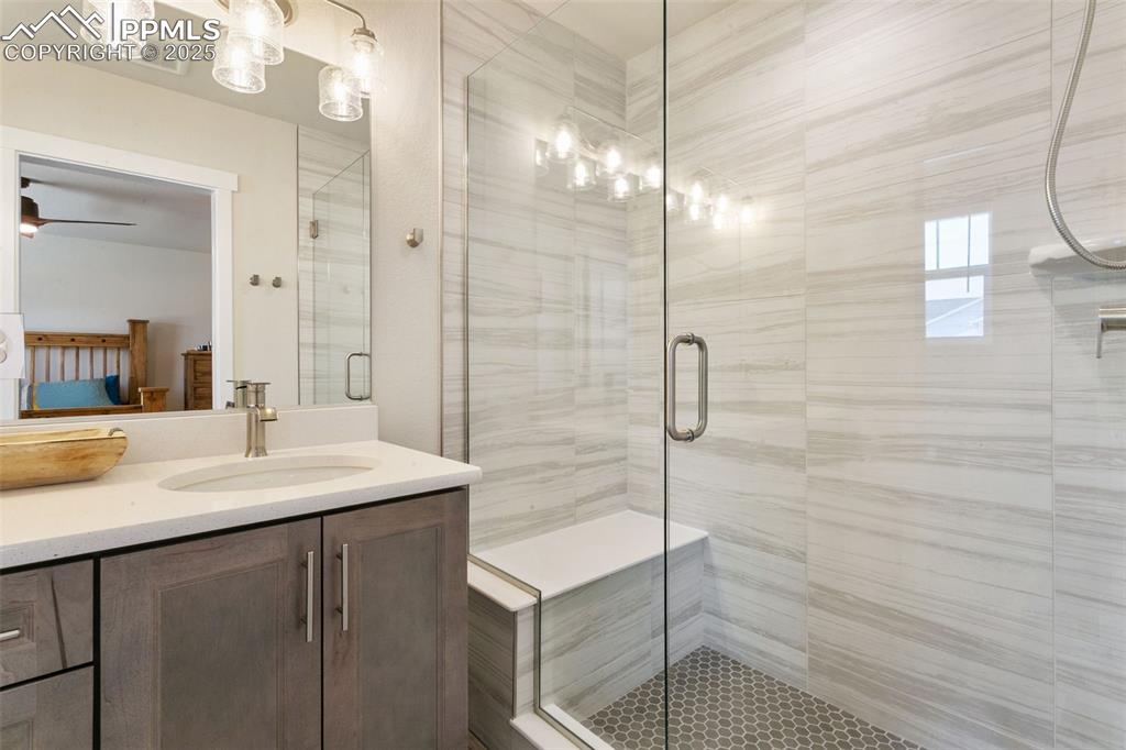 Image 27 of 50: Bathroom featuring a shower stall and vanity