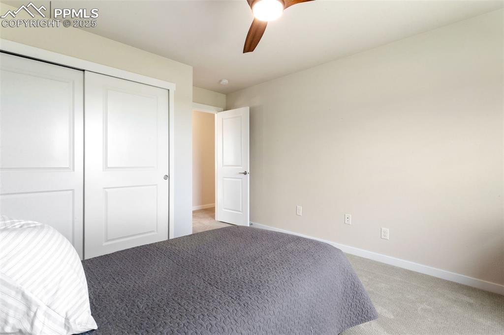 Image 29 of 50: Unfurnished bedroom featuring light carpet, a closet, and ceiling fan