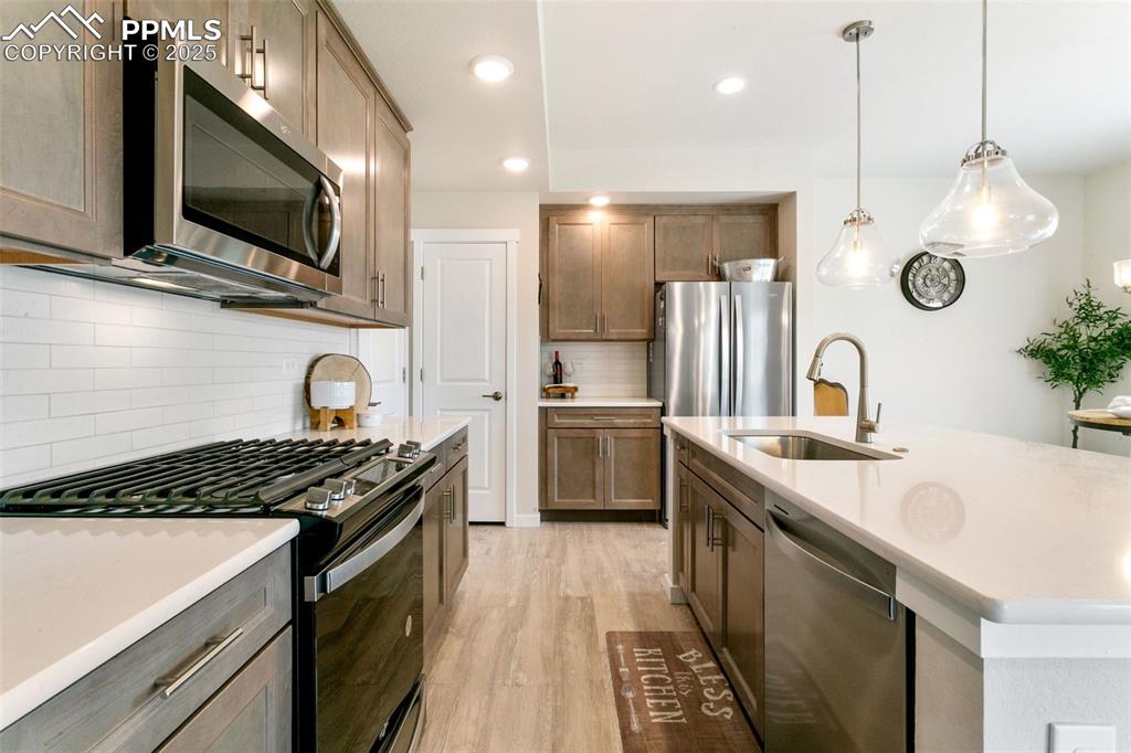 Image 3 of 50: Kitchen featuring appliances with stainless steel finishes, light counterto