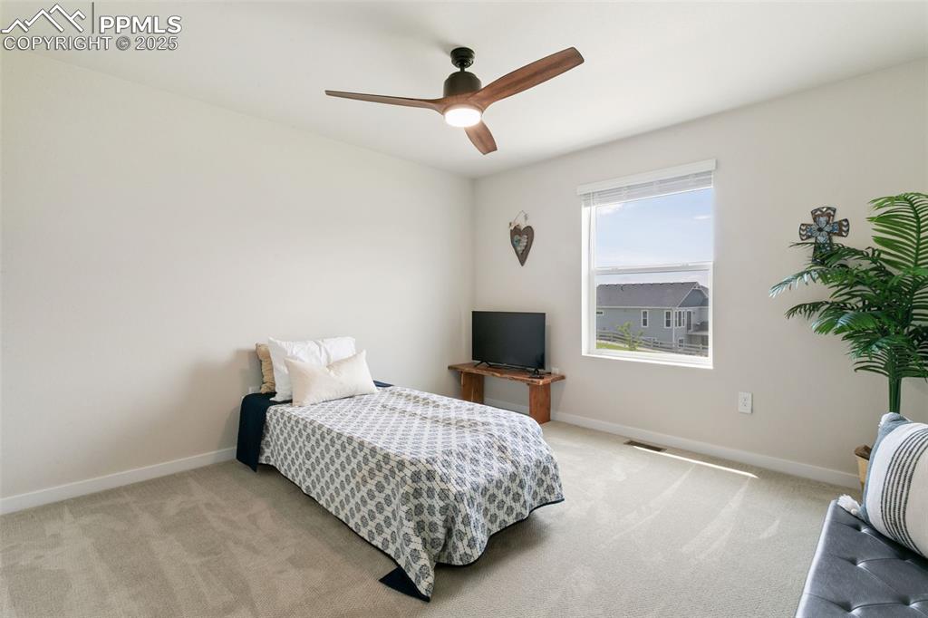 Image 31 of 50: Bedroom with light colored carpet and ceiling fan